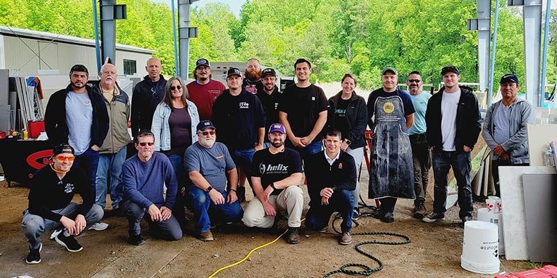 A group of tile installers poses for a picture at a gauged porcelain tile panel installation training class.